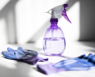 view-of-a-purple-water-cleaning-spray-plastic-bottle-and-bright-purple-cleaning-protection-gloves-on_t20_kodW12